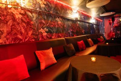 Deux femmes souriantes posent ensemble dans un environnement festif avec un éclairage tamisé.