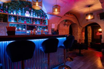 Deux femmes souriantes posent ensemble dans un environnement festif avec un éclairage tamisé.