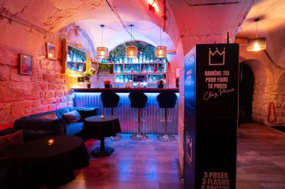 Deux femmes souriantes posent ensemble dans un environnement festif avec un éclairage tamisé.