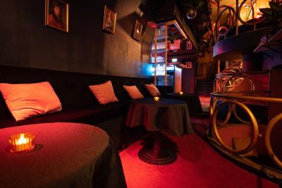 Deux femmes souriantes posent ensemble dans un environnement festif avec un éclairage tamisé.