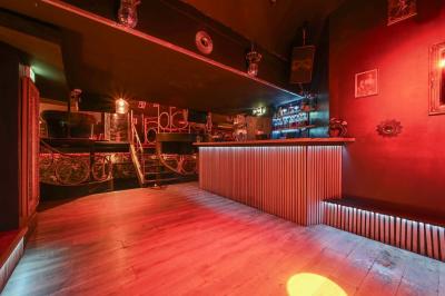 Deux femmes souriantes posent ensemble dans un environnement festif avec un éclairage tamisé.