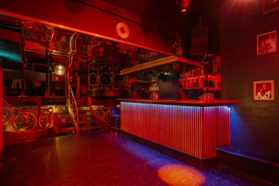 Miniature Location salle Paris 6 (Paris) - Chez Prince #8 Entrée d'un bar ou club avec une enseigne lumineuse en forme de couronne, vélo stationné à gauche et cordon de sécurité.