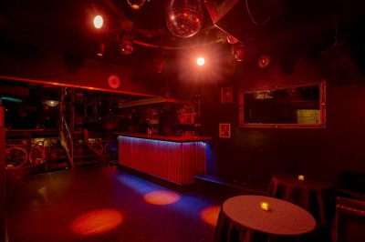 Miniature Location salle Paris 6 (Paris) - Chez Prince #10 Entrée d'un bar ou club avec une enseigne lumineuse en forme de couronne, vélo stationné à gauche et cordon de sécurité.