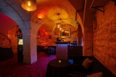 Miniature Location salle Paris 6 (Paris) - Chez Prince #15 Entrée d'un bar ou club avec une enseigne lumineuse en forme de couronne, vélo stationné à gauche et cordon de sécurité.