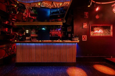 Miniature Location salle Paris 6 (Paris) - Chez Prince #24 Entrée d'un bar ou club avec une enseigne lumineuse en forme de couronne, vélo stationné à gauche et cordon de sécurité.