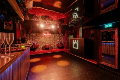 Miniature Location salle Paris 6 (Paris) - Chez Prince #25 Entrée d'un bar ou club avec une enseigne lumineuse en forme de couronne, vélo stationné à gauche et cordon de sécurité.