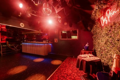 Miniature Location salle Paris 6 (Paris) - Chez Prince #26 Entrée d'un bar ou club avec une enseigne lumineuse en forme de couronne, vélo stationné à gauche et cordon de sécurité.