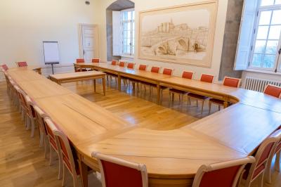 Vue aérienne d'un château entouré de neige, avec une petite ville et un paysage hivernal en arrière-plan.