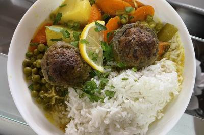 Table garnie de plats variés : boulettes, tartines garnies, sauces et accompagnements dans des assiettes et bols.