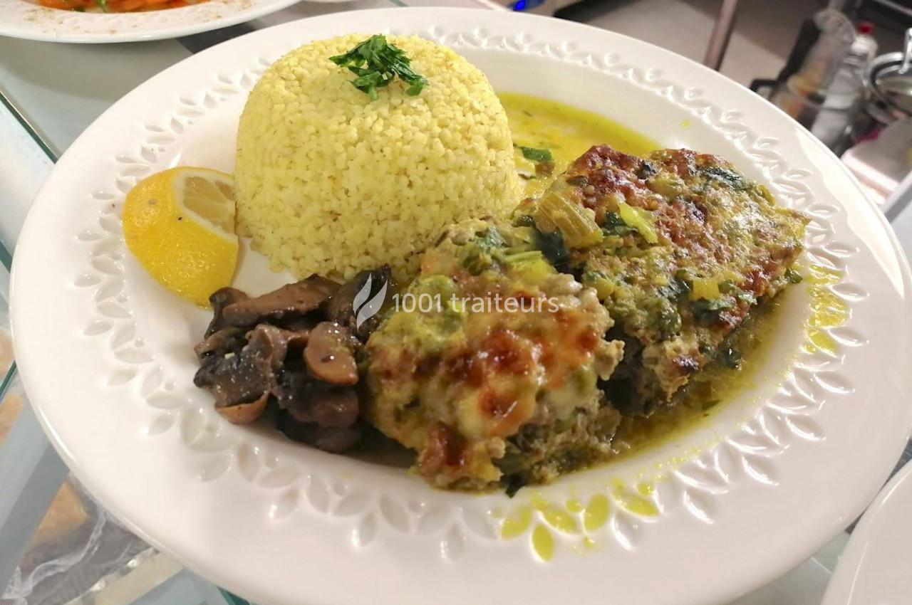 Assiette contenant un gratin de légumes, du riz, des champignons sautés et une tranche de citron.