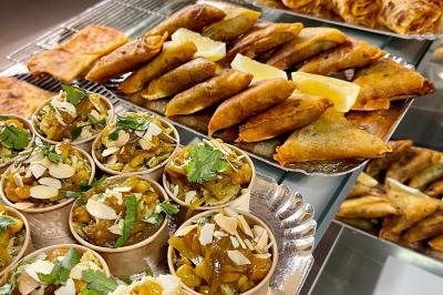 Table garnie de plats variés : boulettes, tartines garnies, sauces et accompagnements dans des assiettes et bols.