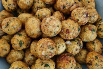 Table garnie de plats variés : boulettes, tartines garnies, sauces et accompagnements dans des assiettes et bols.