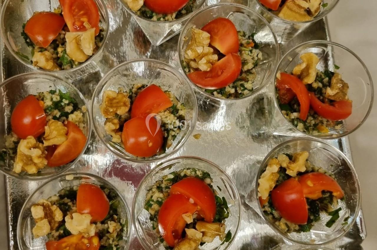 Verrines de taboulé garnies de tomates cerises et noix, disposées sur un plateau argenté.
