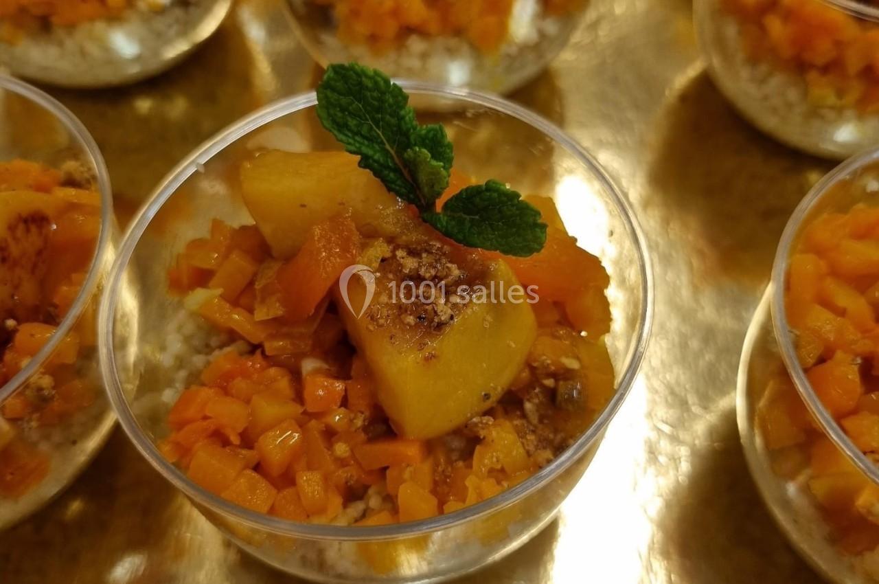 Coupes individuelles de dessert à base de fruits caramélisés, décorées de feuilles de menthe, présentées sur un plateau doré.