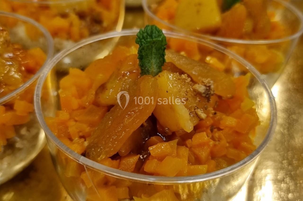 Coupes individuelles de dessert avec fruits coupés en dés, garnies de menthe, présentées sur un plateau doré.