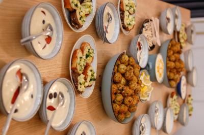 Table garnie de plats variés : boulettes, tartines garnies, sauces et accompagnements dans des assiettes et bols.