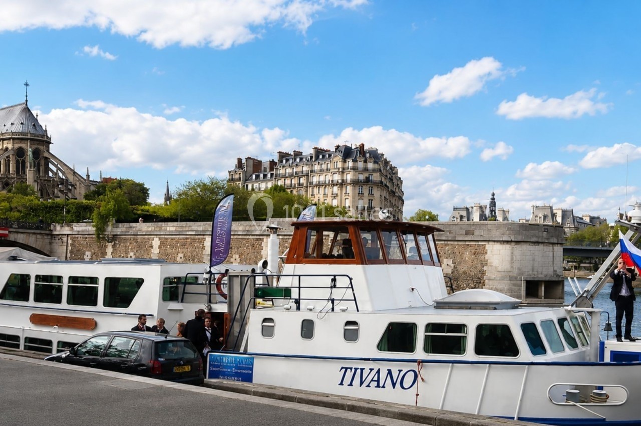 Bateau amarré sur les quais de la Seine à Paris, avec la cathédrale Notre-Dame visible en arrière-plan.