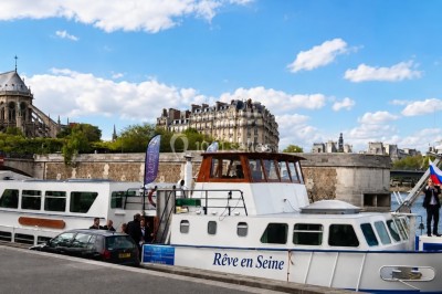 Miniature Location salle Paris 16 (Paris) - Bateau Le Rêve sur Seine #7 Un capitaine en uniforme utilise une radio dans la cabine d'un bateau, avec vue sur une rivière bordée d'arbres.