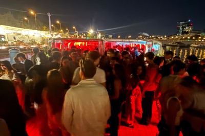 Salle intérieure d'un bateau aménagée avec des tables, des fauteuils et des ballons suspendus au plafond.