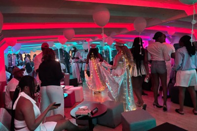 Salle intérieure d'un bateau aménagée avec des tables, des fauteuils et des ballons suspendus au plafond.