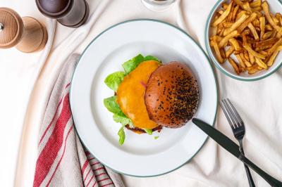 Abri en bois avec trois cibles de fléchettes fixées, une étagère avec une pomme et une autre avec un vase de fleurs.