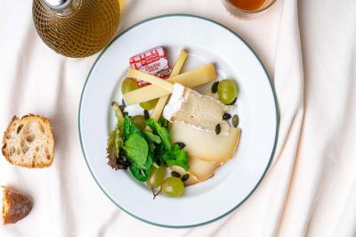Abri en bois avec trois cibles de fléchettes fixées, une étagère avec une pomme et une autre avec un vase de fleurs.