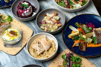 Abri en bois avec trois cibles de fléchettes fixées, une étagère avec une pomme et une autre avec un vase de fleurs.