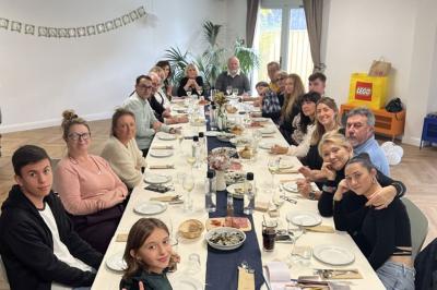 Abri en bois avec trois cibles de fléchettes fixées, une étagère avec une pomme et une autre avec un vase de fleurs.