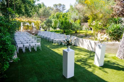 Une mariée en robe blanche pose sur une plateforme tournante lors d'un événement en extérieur, entourée d'invités.