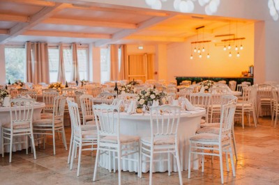 Une mariée en robe blanche pose sur une plateforme tournante lors d'un événement en extérieur, entourée d'invités.