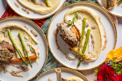 Une mariée en robe blanche pose sur une plateforme tournante lors d'un événement en extérieur, entourée d'invités.