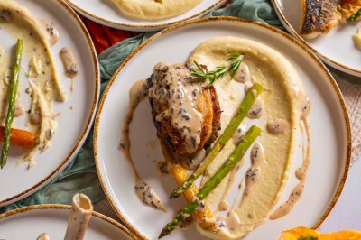 Une mariée en robe blanche pose sur une plateforme tournante lors d'un événement en extérieur, entourée d'invités.