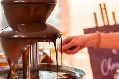 Une mariée en robe blanche pose sur une plateforme tournante lors d'un événement en extérieur, entourée d'invités.