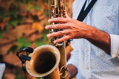 Une mariée en robe blanche pose sur une plateforme tournante lors d'un événement en extérieur, entourée d'invités.