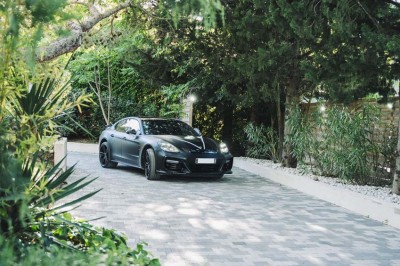 Une mariée en robe blanche pose sur une plateforme tournante lors d'un événement en extérieur, entourée d'invités.