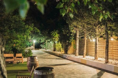 Une mariée en robe blanche pose sur une plateforme tournante lors d'un événement en extérieur, entourée d'invités.