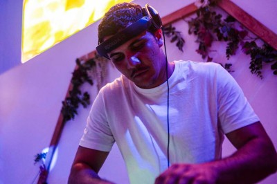 Une mariée en robe blanche pose sur une plateforme tournante lors d'un événement en extérieur, entourée d'invités.