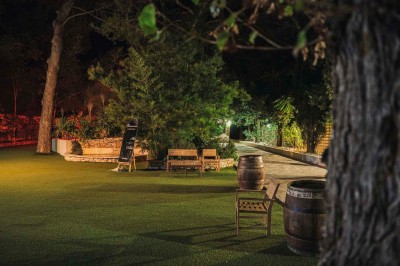 Une mariée en robe blanche pose sur une plateforme tournante lors d'un événement en extérieur, entourée d'invités.