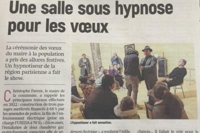 Un hypnotiseur anime une séance devant un public assis dans une salle, dans le cadre d'une cérémonie officielle.