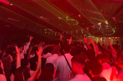 Salle de réception avec tables dressées, vue depuis une scène équipée d'une console de mixage lumineuse.