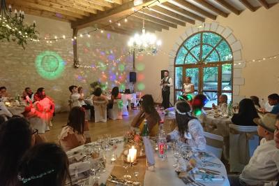 Salle de réception avec tables dressées, vue depuis une scène équipée d'une console de mixage lumineuse.