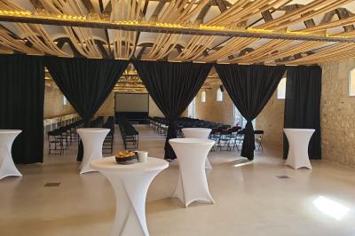 Groupe de personnes rassemblées dans une cour extérieure arborée avec des tables dressées pour un événement.
