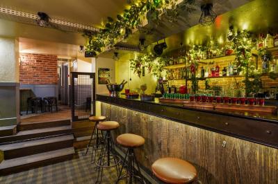 Salle de restaurant avec banquettes vertes, tables en bois garnies de plats variés et seau à champagne au centre.