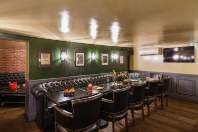 Salle de restaurant avec banquettes vertes, tables en bois garnies de plats variés et seau à champagne au centre.