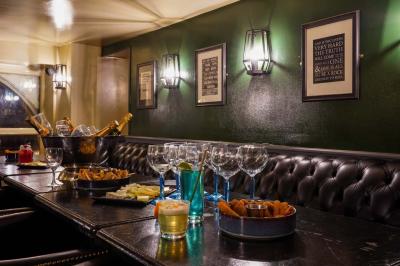 Salle de restaurant avec banquettes vertes, tables en bois garnies de plats variés et seau à champagne au centre.