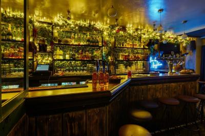 Salle de restaurant avec banquettes vertes, tables en bois garnies de plats variés et seau à champagne au centre.