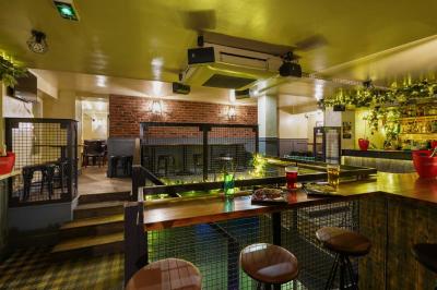 Table garnie de plats variés, bouteilles de champagne dans un seau à glace, décor intérieur avec banquettes et éclairage…