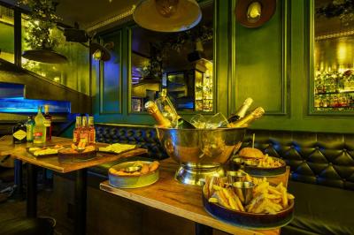 Table garnie de plats variés, bouteilles de champagne dans un seau à glace, décor intérieur avec banquettes et éclairage…