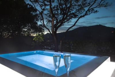 Salon lumineux avec canapé blanc, table basse, bureau près de la fenêtre et vue sur un jardin verdoyant.