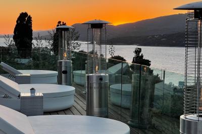 Salon lumineux avec canapé blanc, table basse, bureau près de la fenêtre et vue sur un jardin verdoyant.